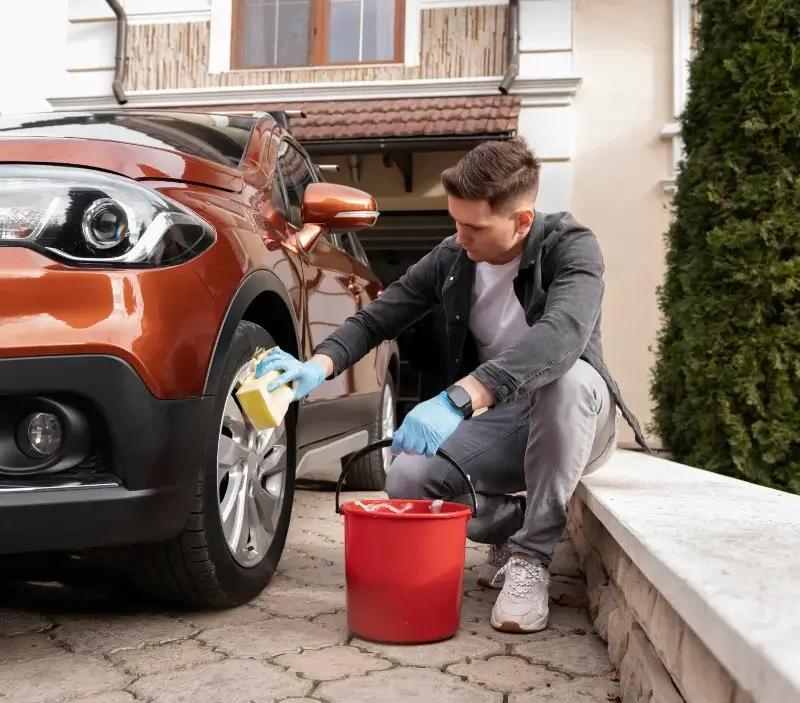 Lavage auto à domicile Dinozé : professionnel intervenant sur un véhicule